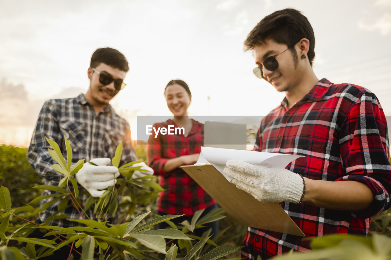 Coworkers examining plants in farm