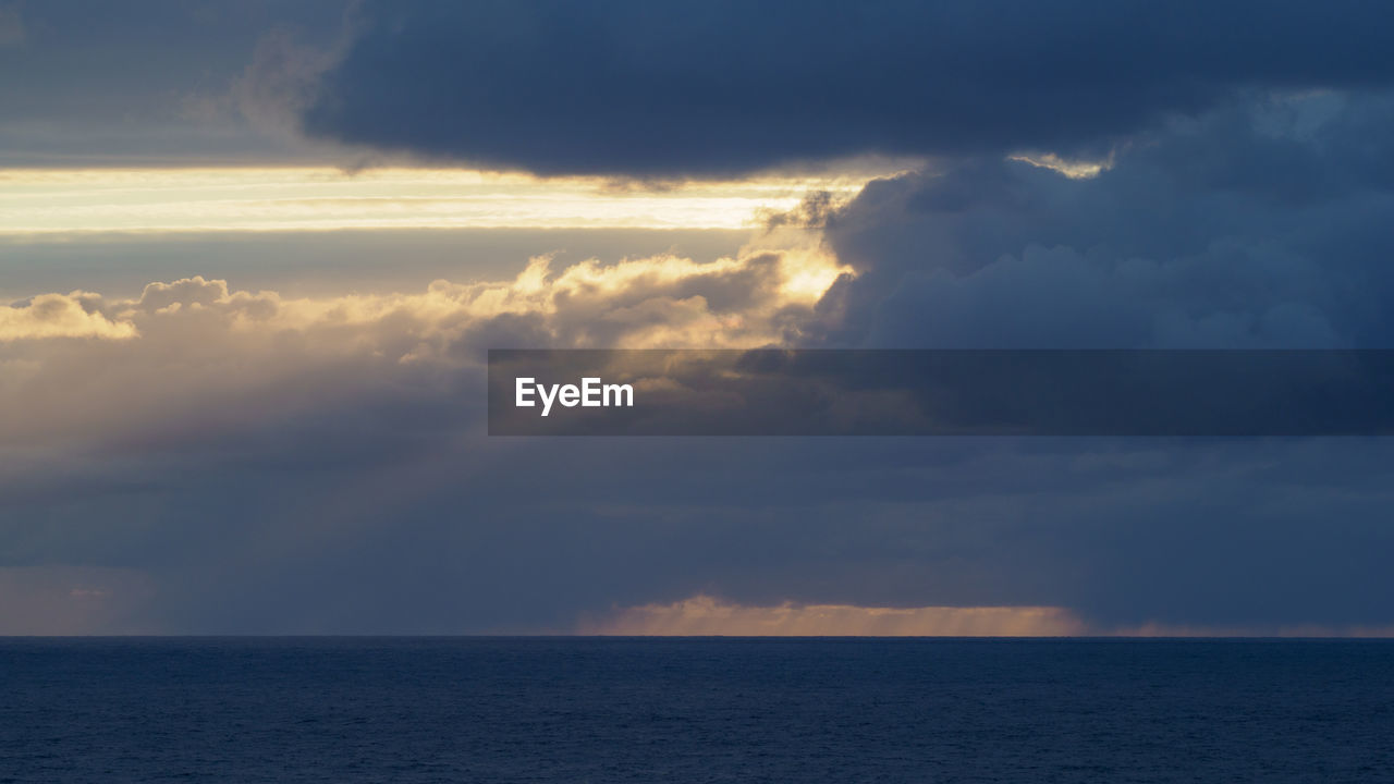 SCENIC VIEW OF SEA AT SUNSET