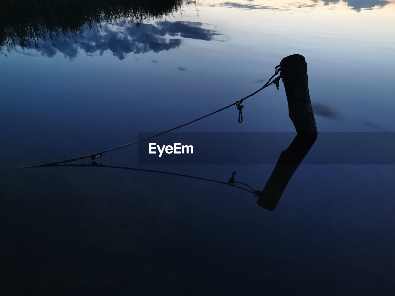 water, reflection, fishing, nature, lake, one person, beauty in nature, sky, silhouette, tranquility, fishing rod, scenics - nature, activity, outdoors, tranquil scene, rod, rope, animal