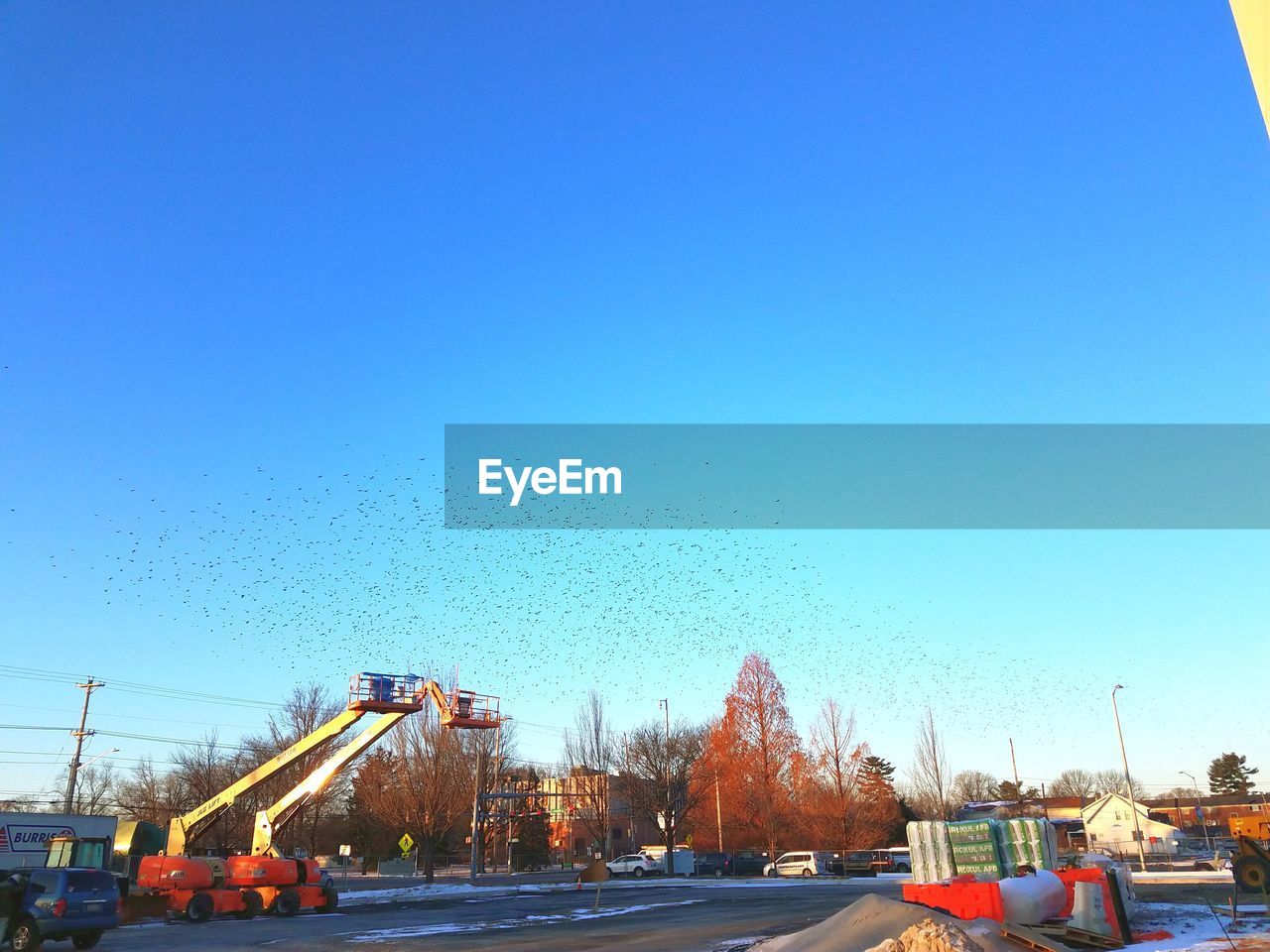 FLOCK OF CARS AGAINST CLEAR BLUE SKY