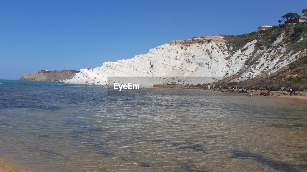 SCENIC VIEW OF SEA AND MOUNTAINS AGAINST CLEAR SKY