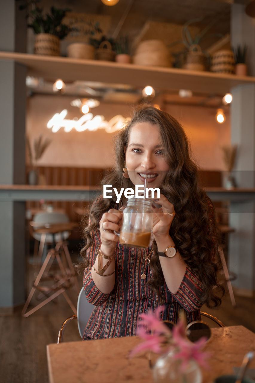 Young woman drinking coffee at coffee shop in munich