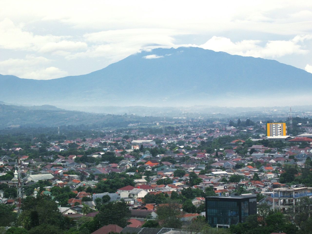 Cityscape by mountain against sky