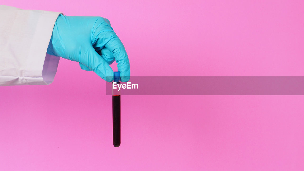 hand, protective glove, protection, protective workwear, healthcare and medicine, pink, indoors, studio shot, colored background, one person, security, science, safety glove, copy space, blue, occupation, holding, adult, surgical glove, scientific experiment, rubber, hygiene, laboratory, finger, glove, close-up, research