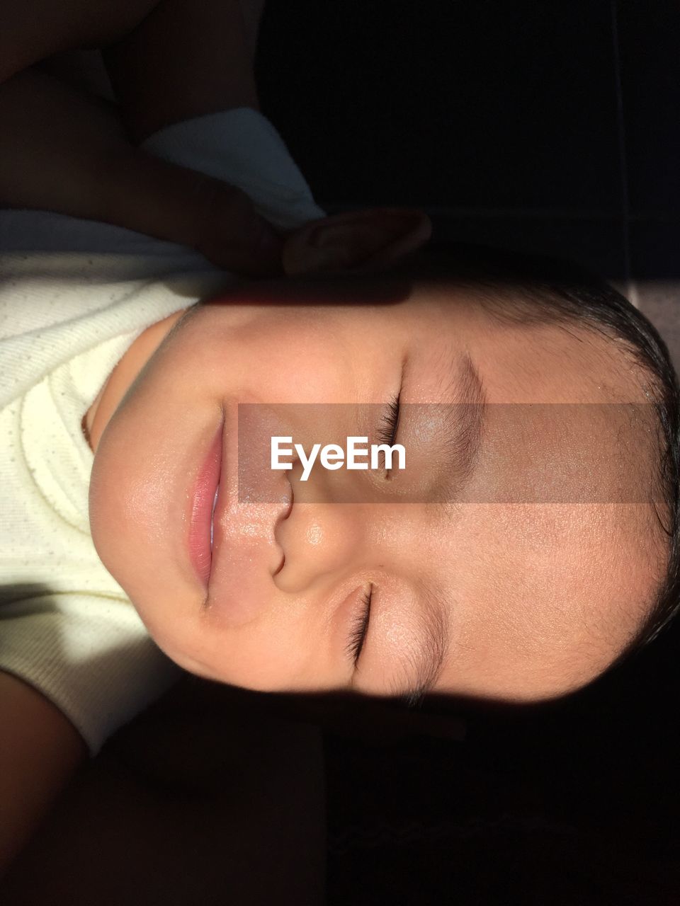 Close-up of baby sleeping in darkroom