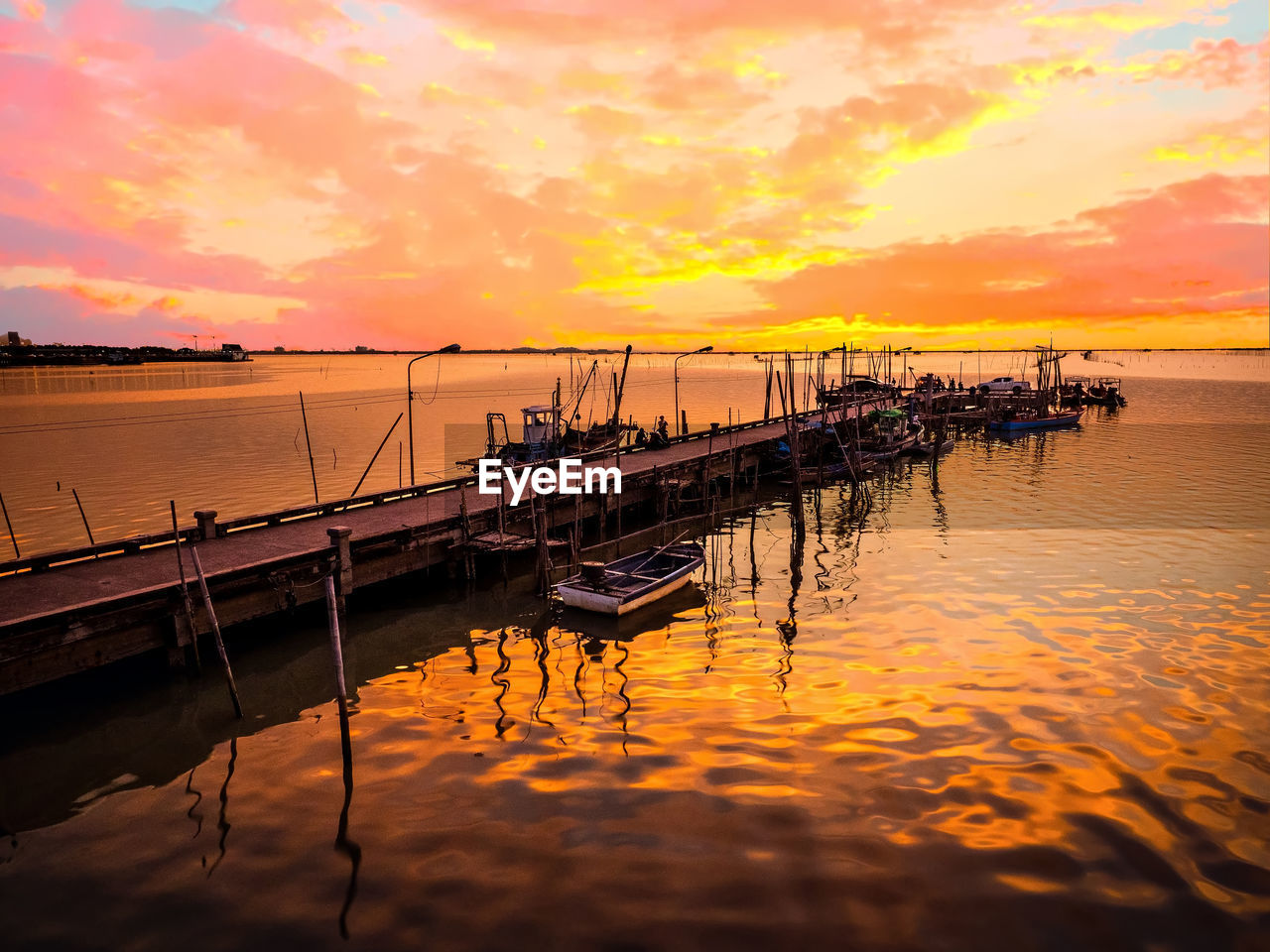 FISHING BOAT MOORED AT PIER AGAINST SKY DURING SUNSET