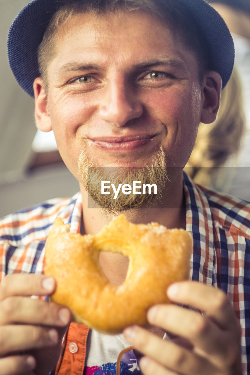 Portrait of smiling man holding donut