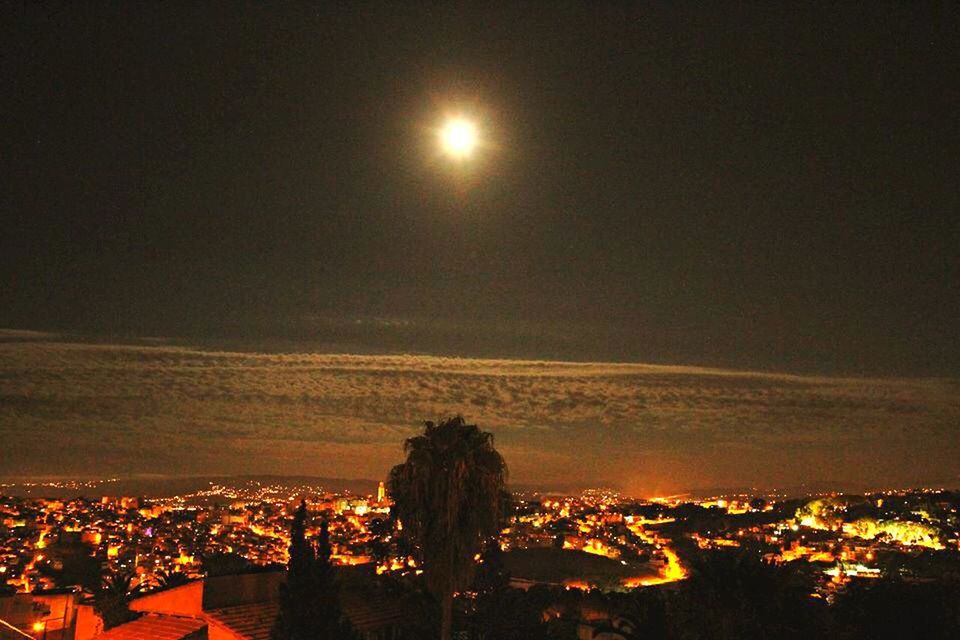 VIEW OF ILLUMINATED CITYSCAPE AT NIGHT