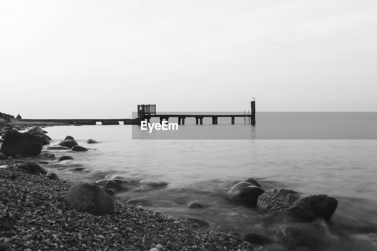 Pier on sea against clear sky