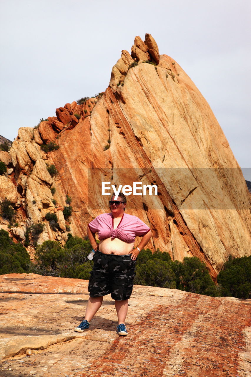 Full length of mid adult woman standing against rock formation at national park