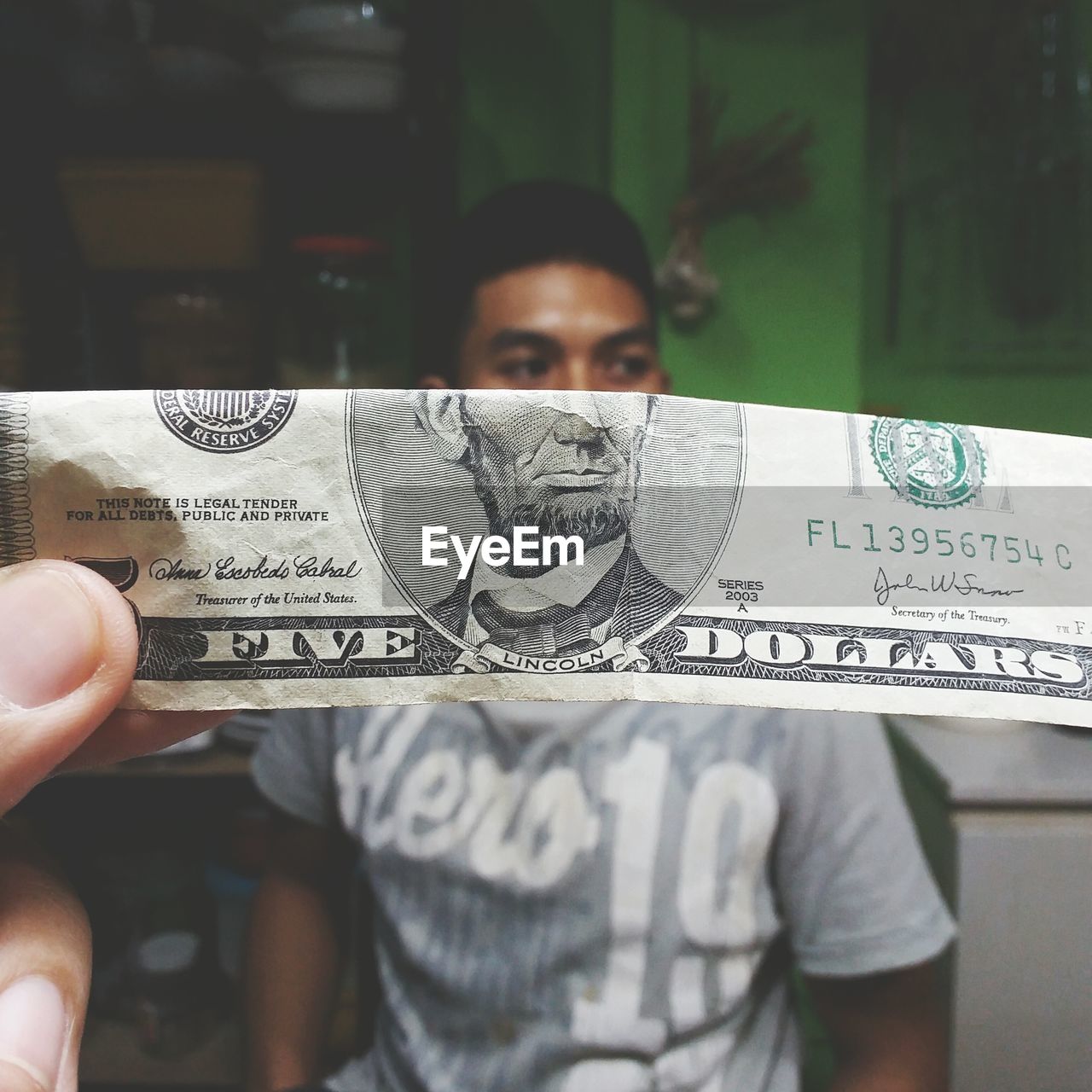 Close-up of paper currency against man in background
