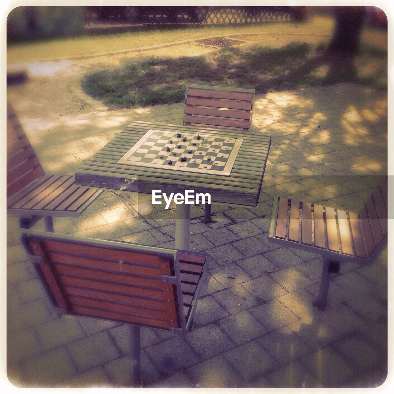 Board game on table with empty chairs outdoors