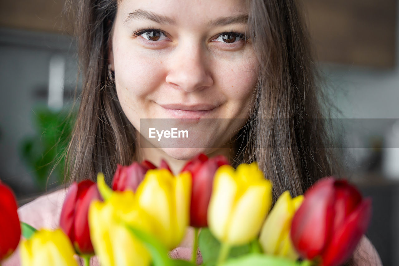 close-up portrait of smiling young woman eating food at home