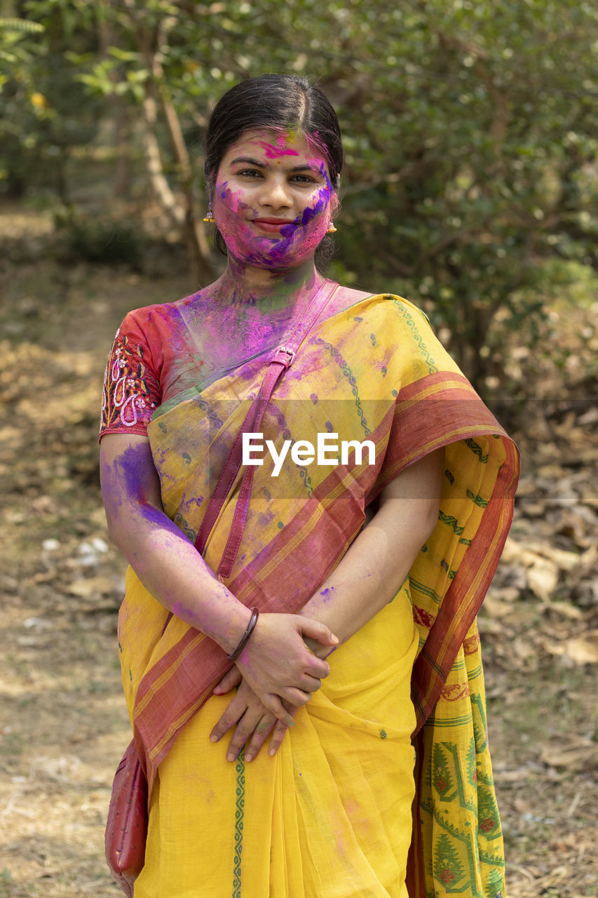 An indian bengali woman in saree and colorful face with powder paint during holi