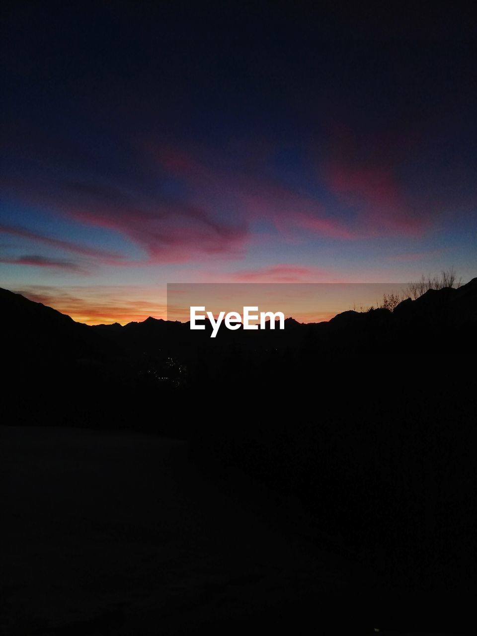 SCENIC VIEW OF SILHOUETTE MOUNTAIN AGAINST SKY AT SUNSET