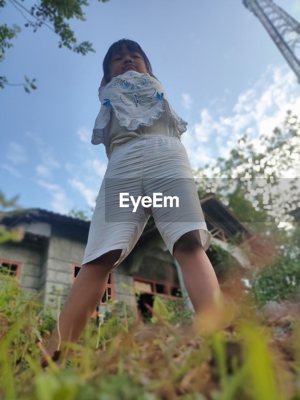 WOMAN STANDING WITH UMBRELLA AGAINST SKY