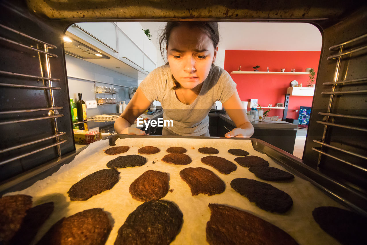 Young woman baking cookies in kitchen