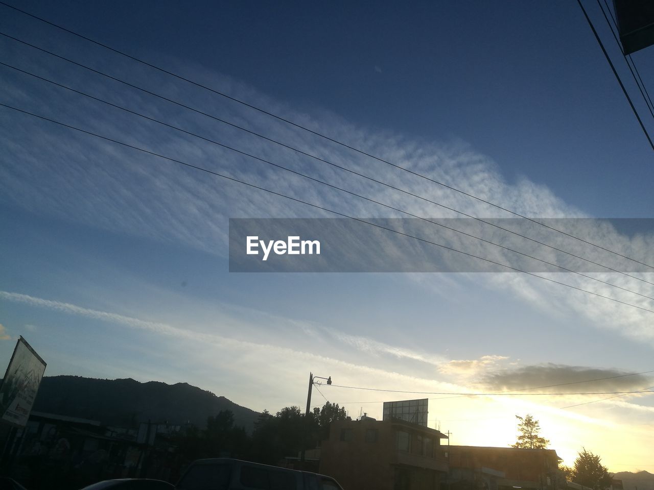 LOW ANGLE VIEW OF SILHOUETTE VAPOR TRAILS AGAINST SKY