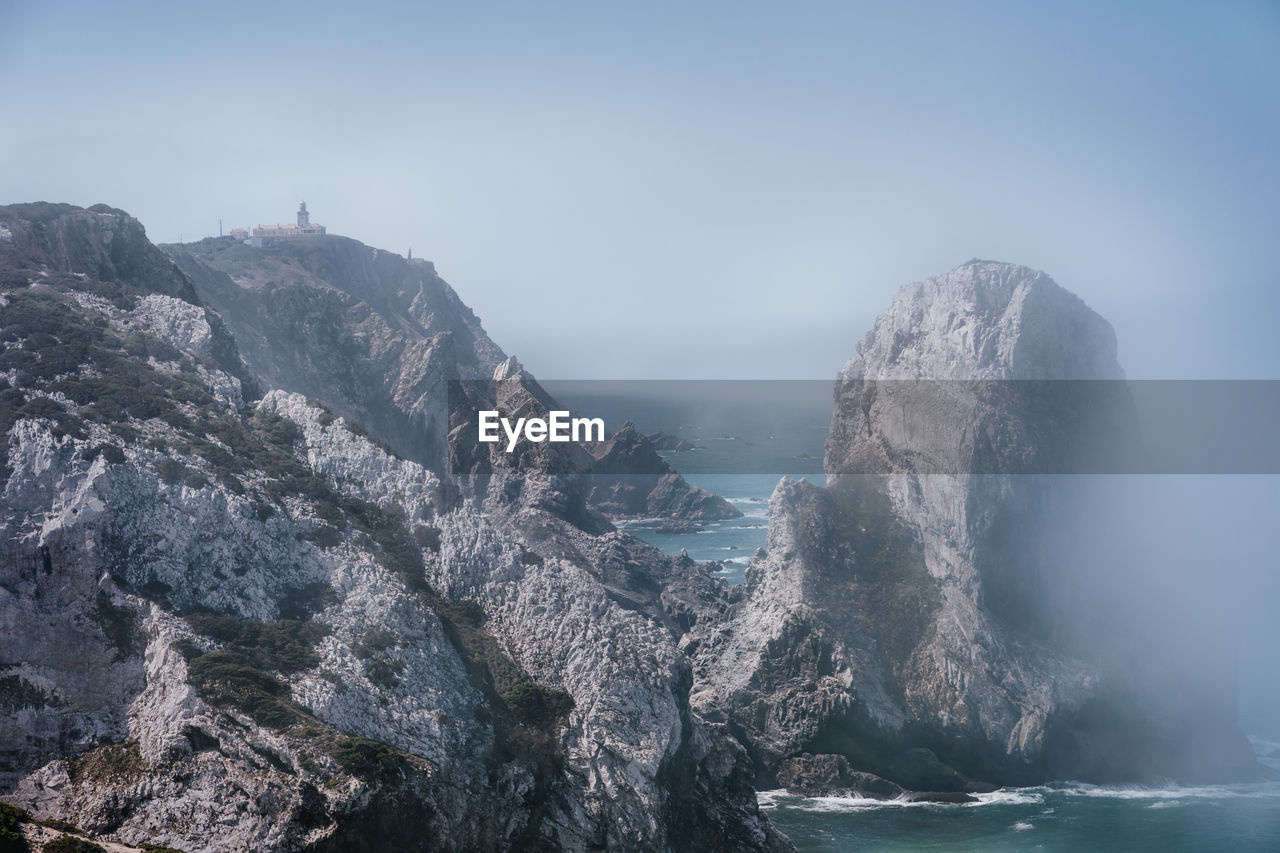 Rock formations against sky in foggy weather