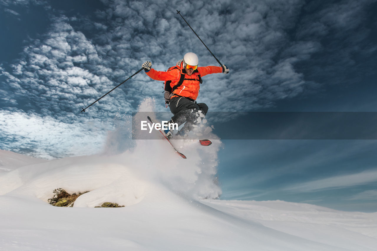 A girl makes a jump with glo skis in deep snow