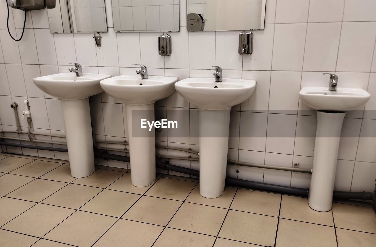 bathroom, tile, flooring, hygiene, room, public building, public restroom, floor, home, tiled floor, domestic room, toilet, sink, domestic bathroom, indoors, plumbing fixture, urinal, restroom, household equipment, in a row, no people, bidet, clean, white, tap