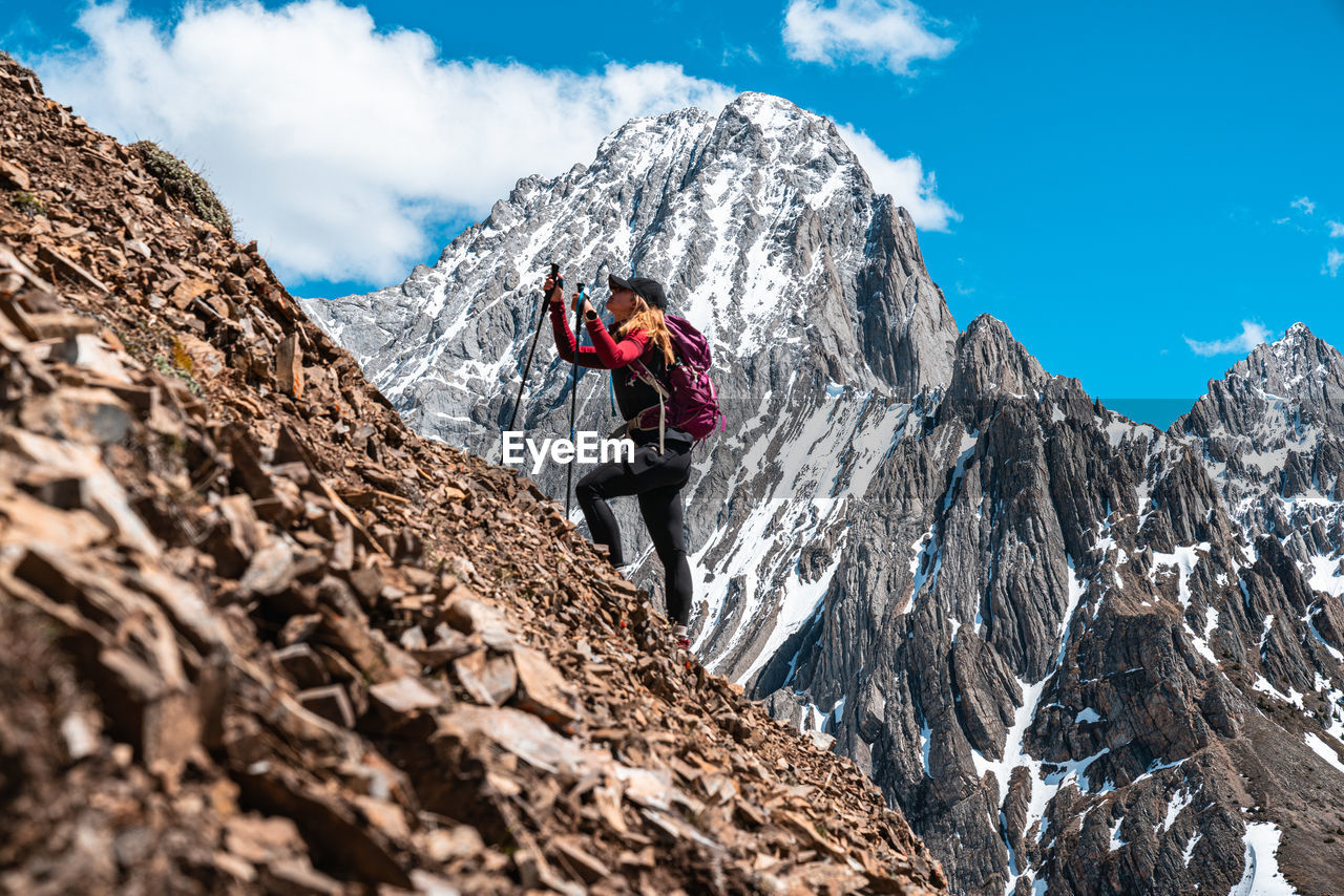 Hiker climbing up rocky scree slope on grizzly peak mount even-thomas