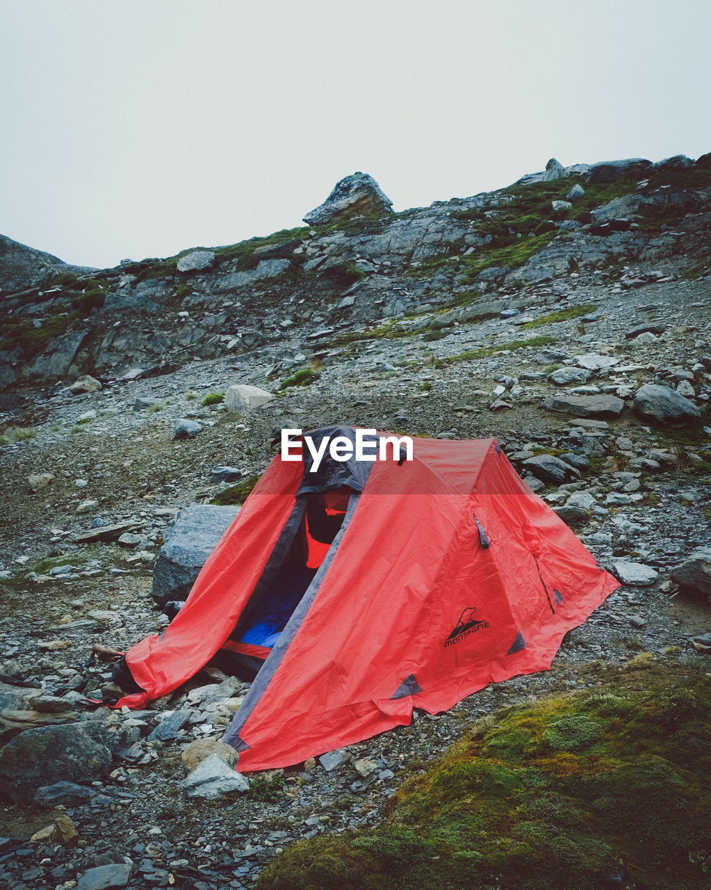 TENT BY ROCK AGAINST SKY