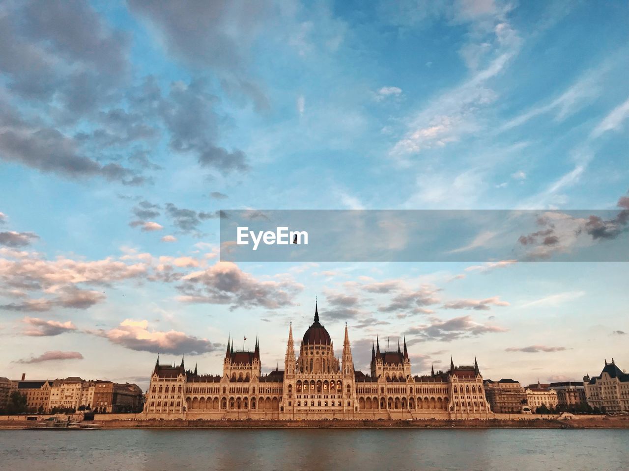 View of building and river against cloudy sky