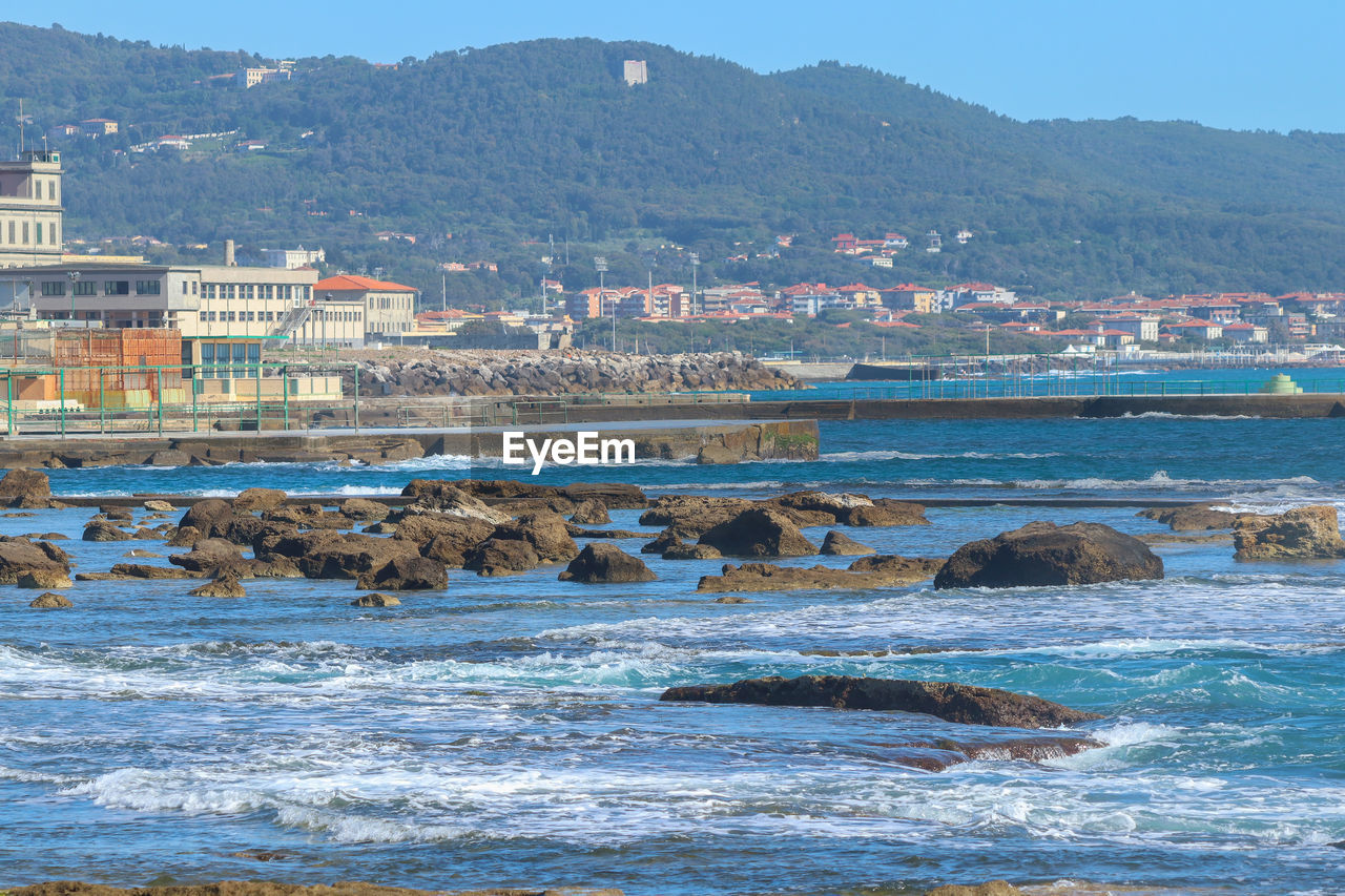 The sea of livorno with a view of the port and the hills.