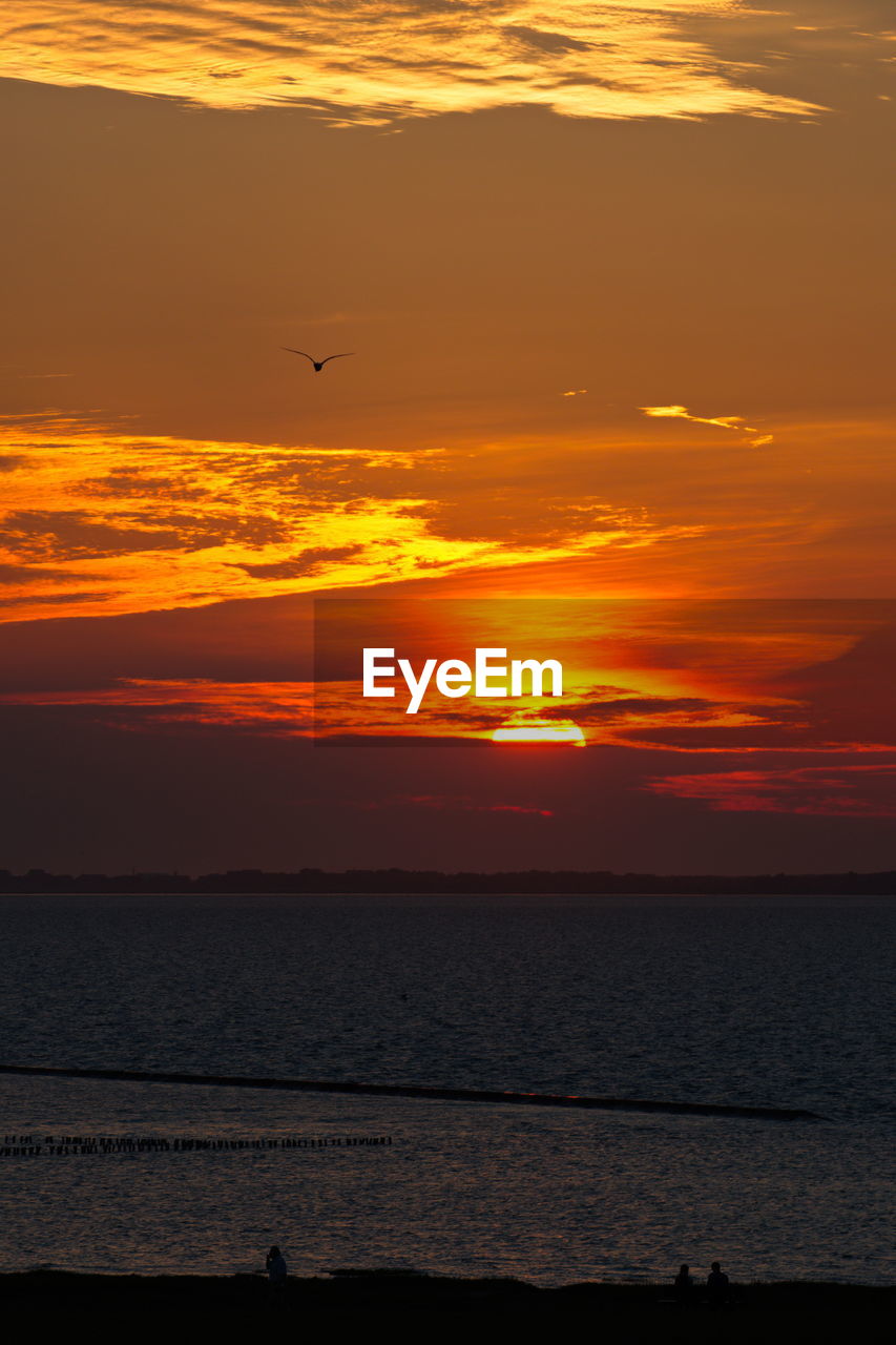Scenic view of sea against sunset sky