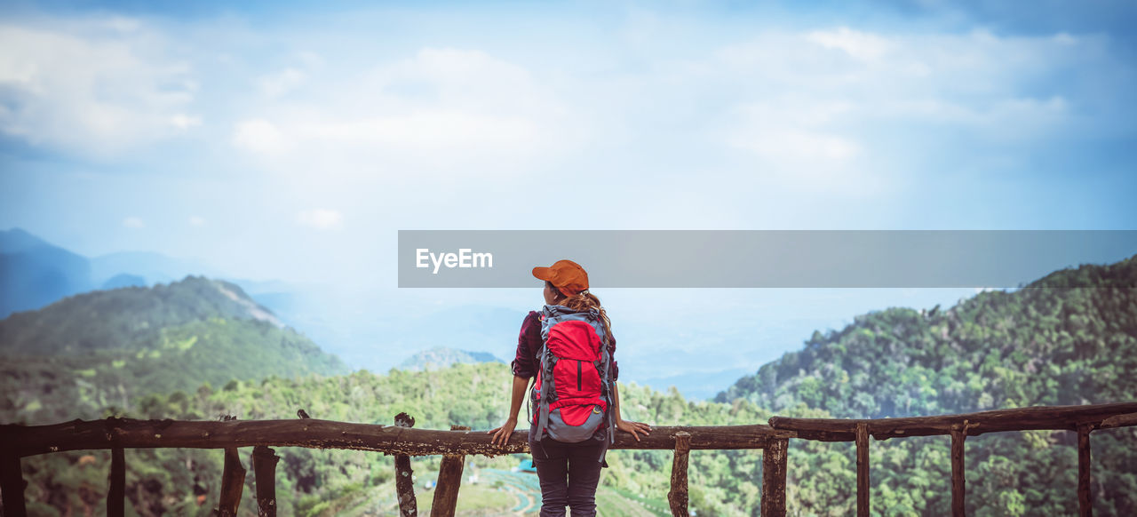 rear view of woman walking on mountain against sky