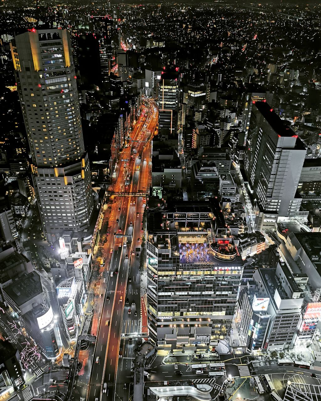 HIGH ANGLE VIEW OF MODERN BUILDINGS IN CITY DURING NIGHT