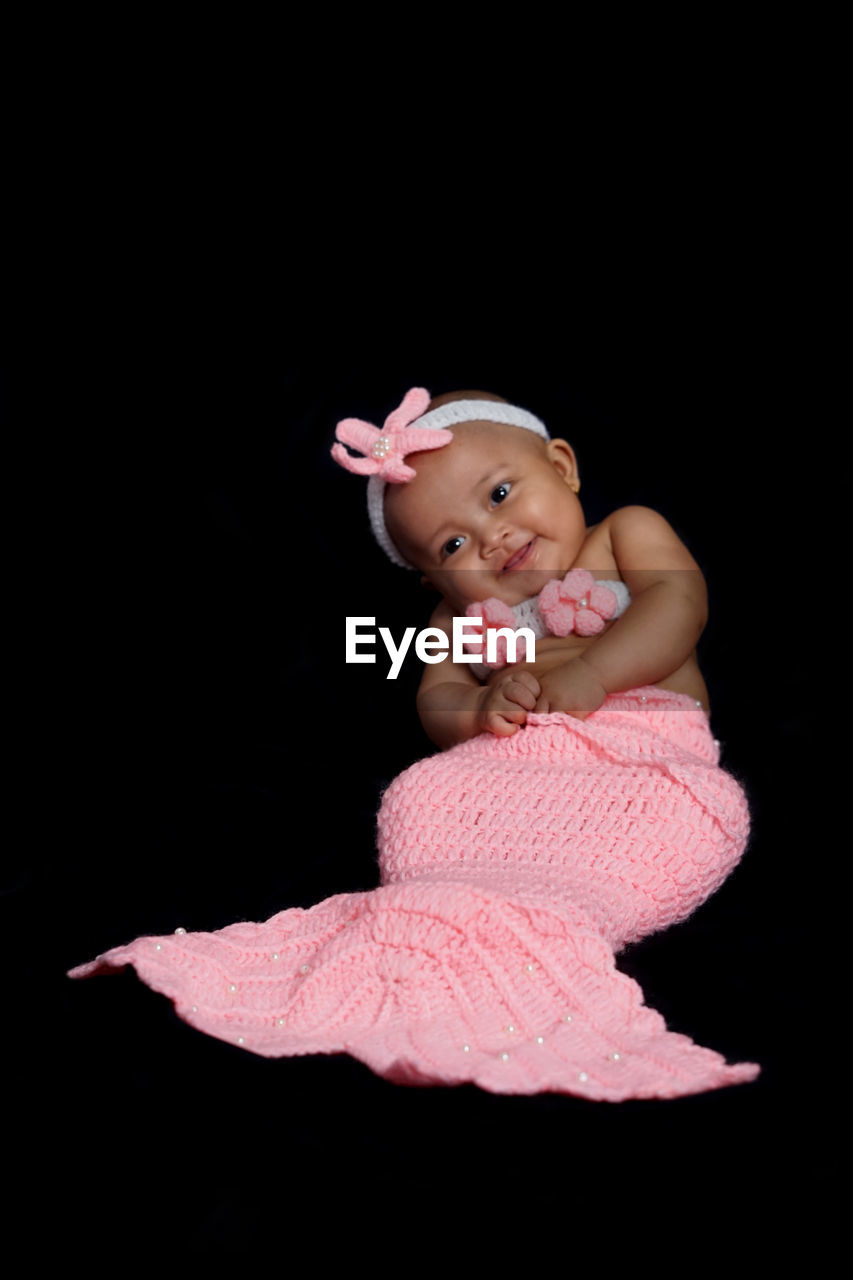 Cute baby girl against black background