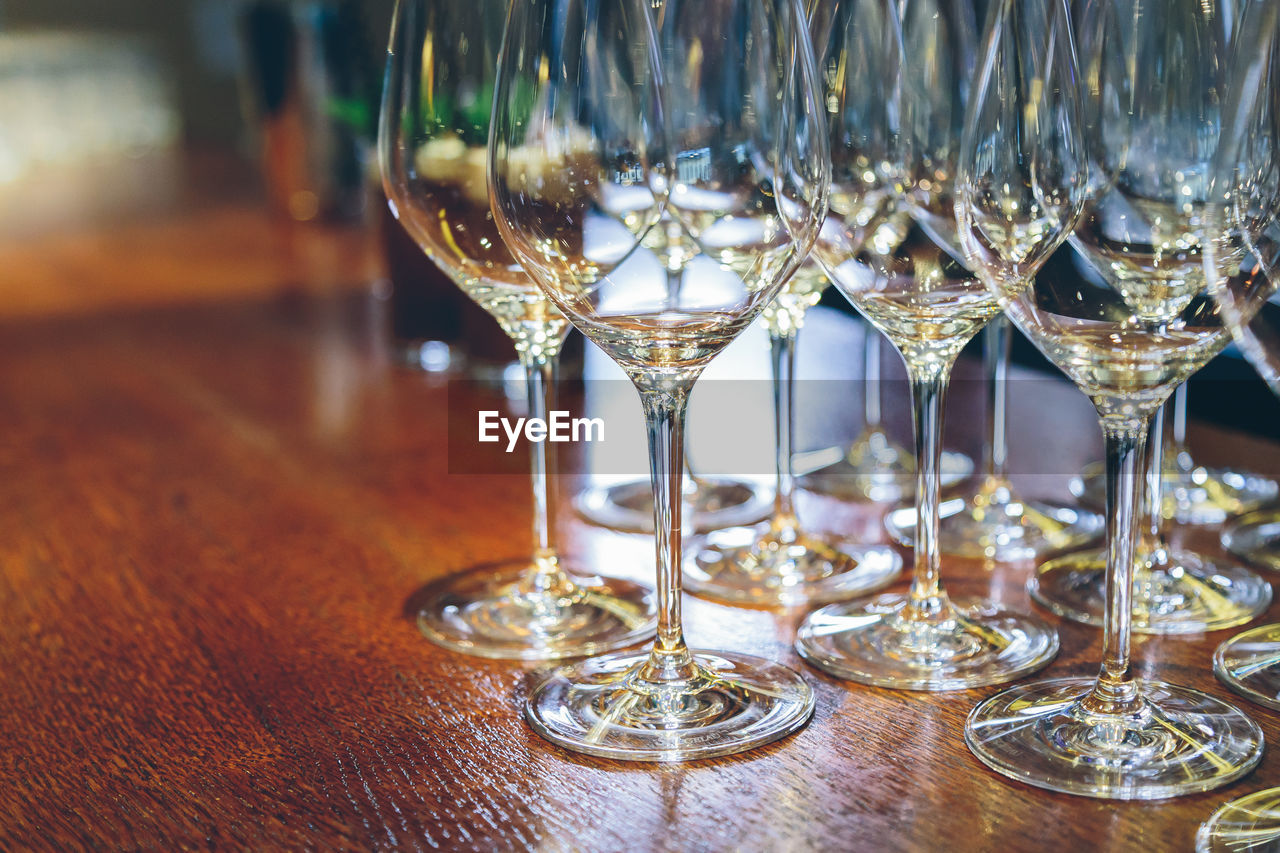 CLOSE-UP OF WINE GLASSES ON GLASS TABLE