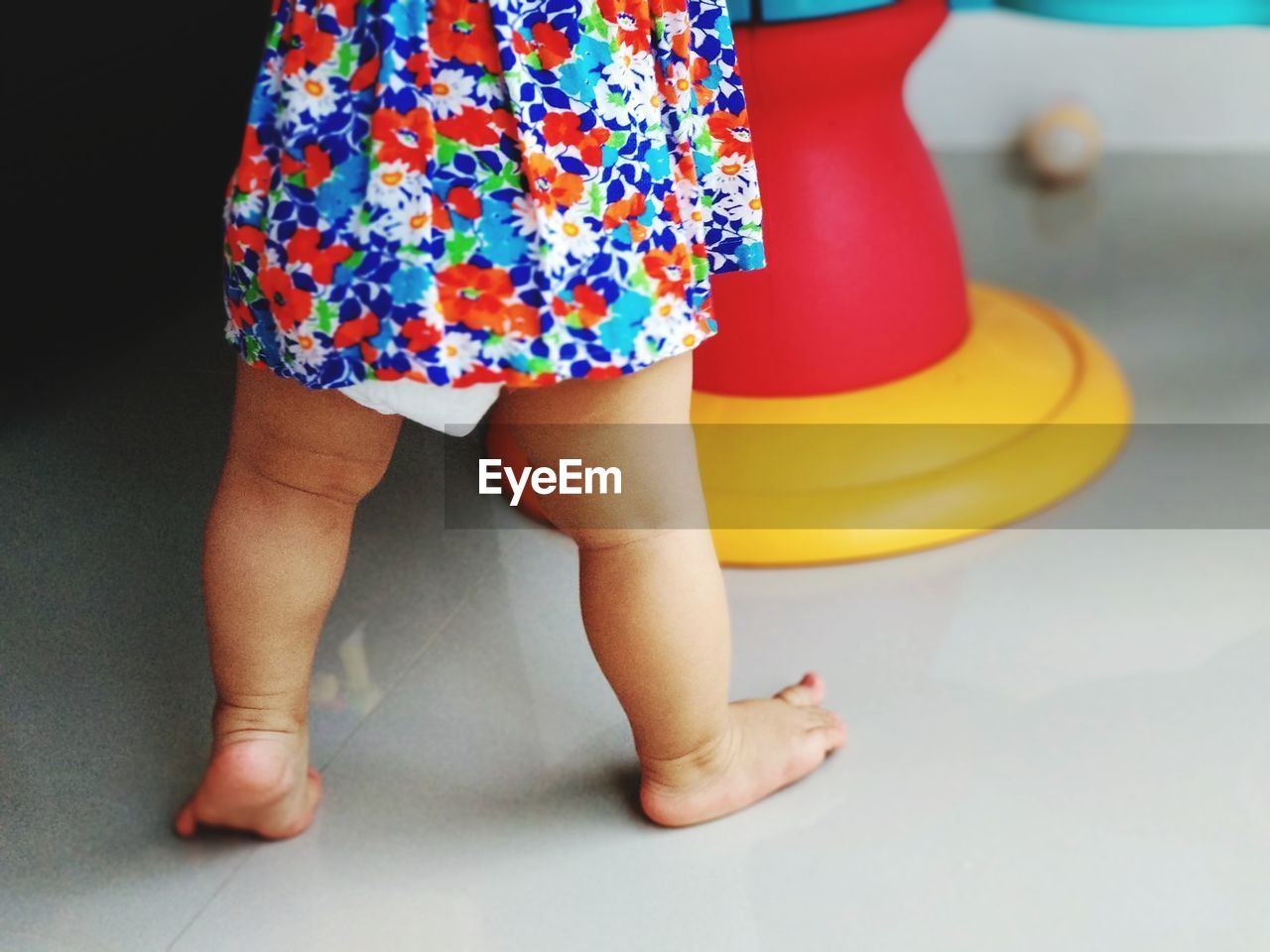 Low section of baby girl standing on tiled floor