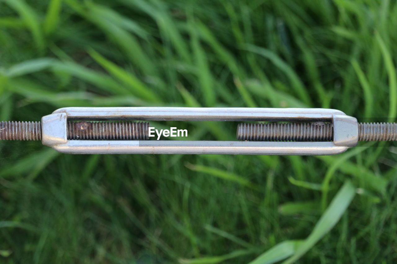 Close-up of metal over grassy field