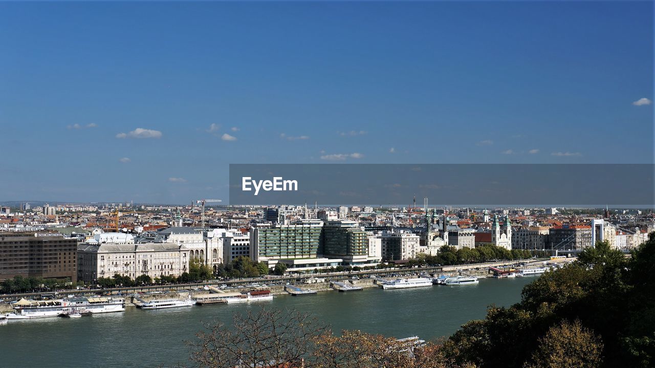 River amidst buildings in city against sky