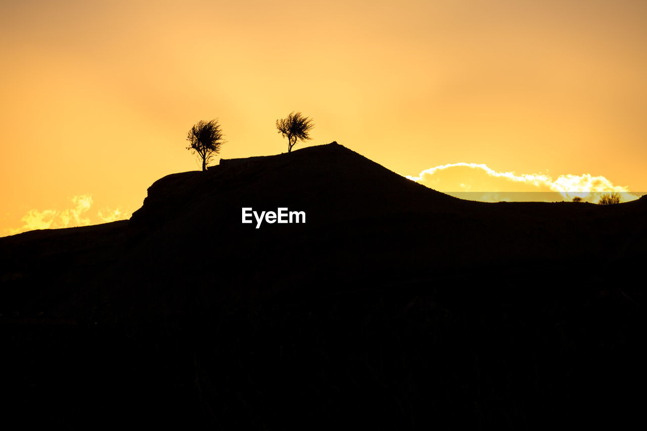 LOW ANGLE VIEW OF SILHOUETTE MOUNTAINS AGAINST SKY AT SUNSET