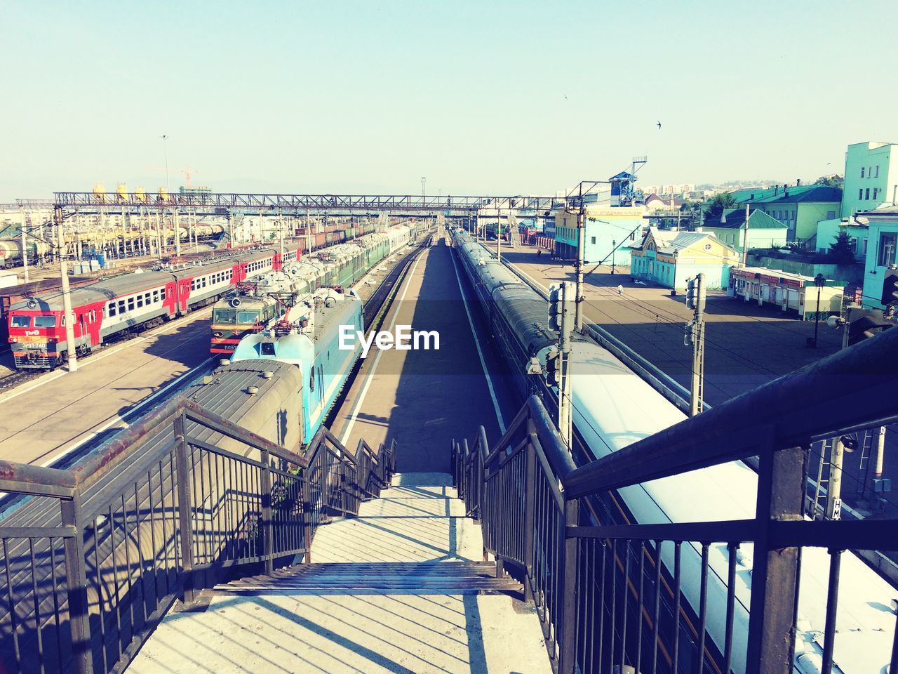 Railroad station with trains under clear sky