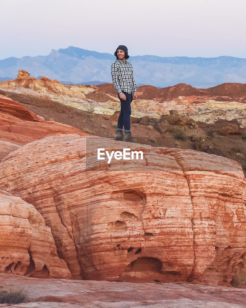 Full length of young man standing on rock formation