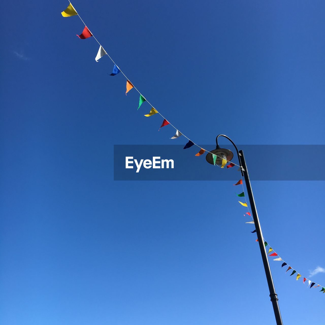 Low angle view of paper decoration by street light against clear sky