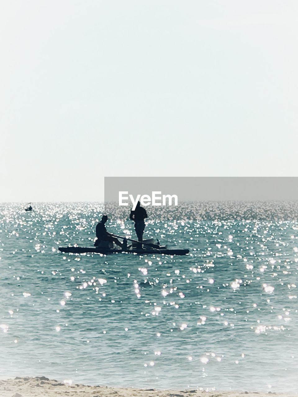 SILHOUETTE MAN IN SEA AGAINST CLEAR SKY