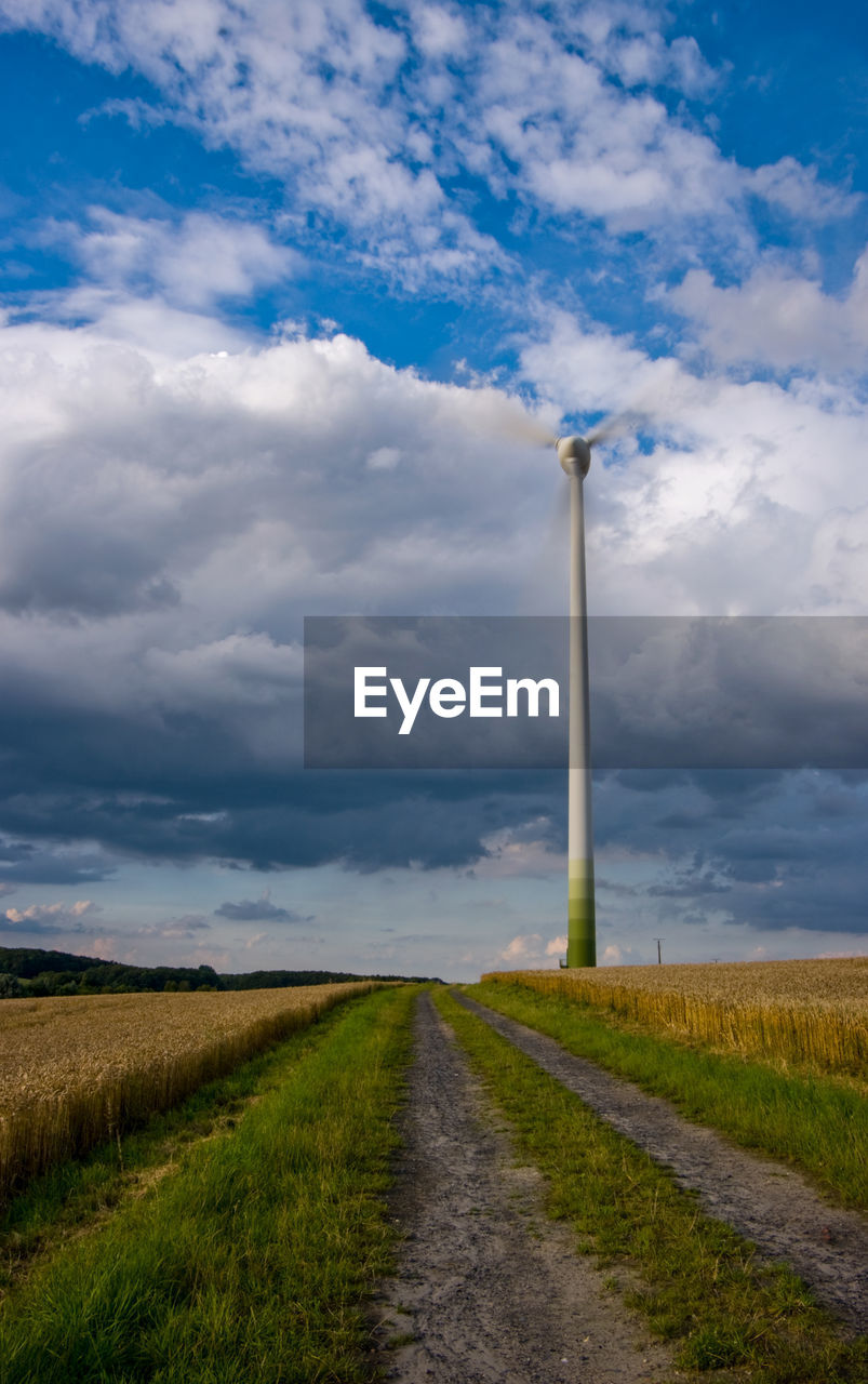 Road amidst field against sky