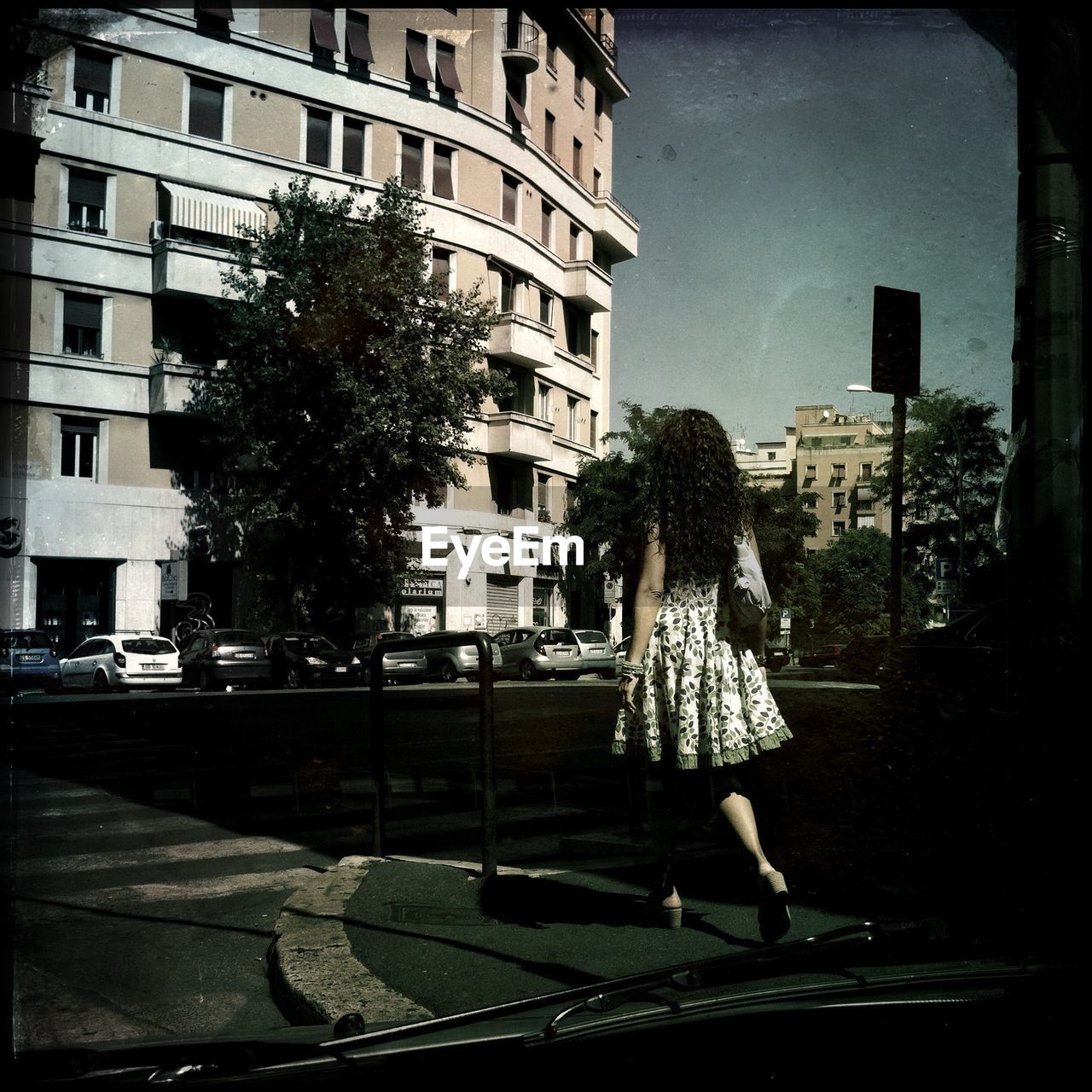 Full length of woman walking on footpath seen through windshield