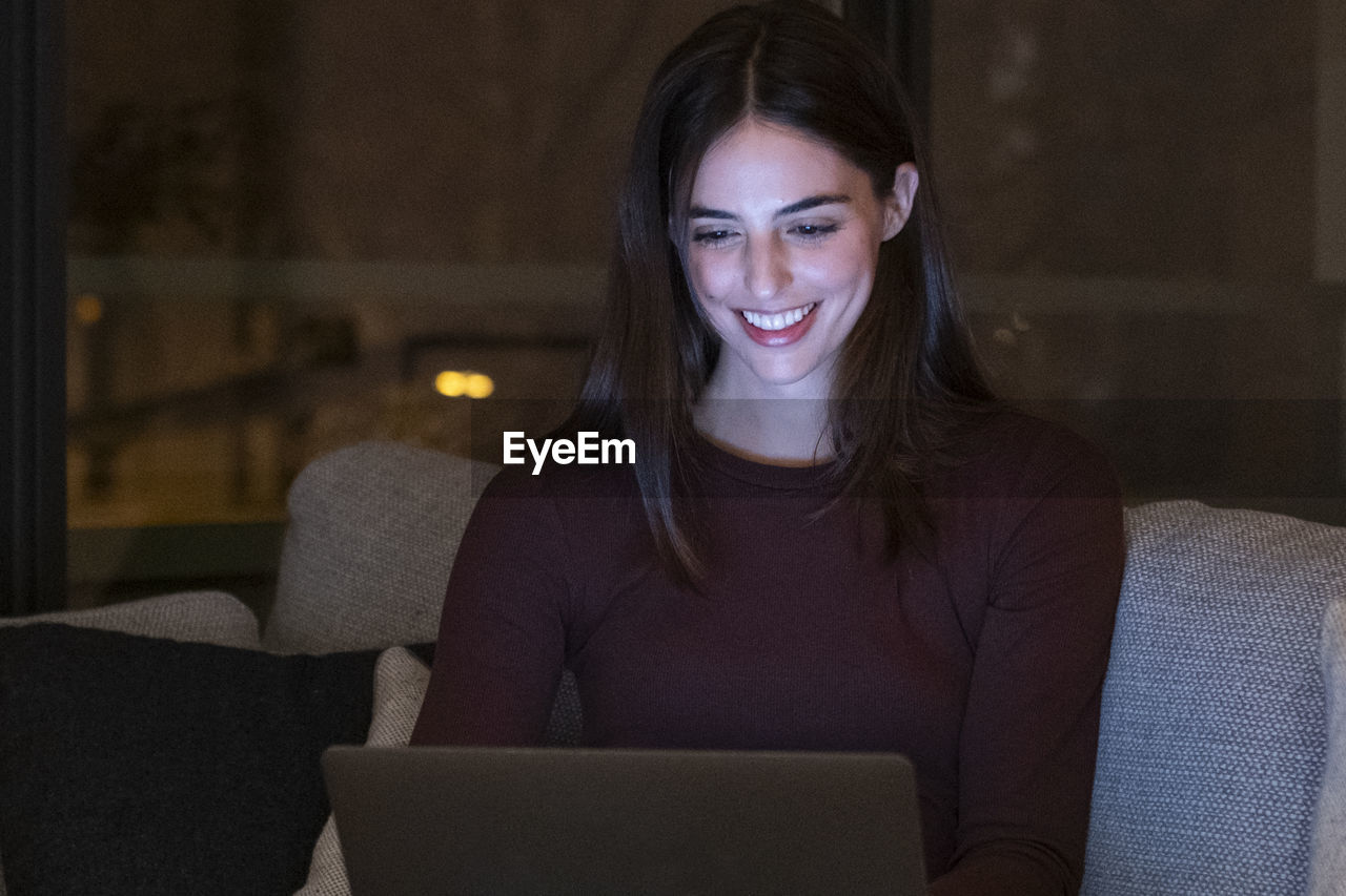 young woman using laptop while sitting at home