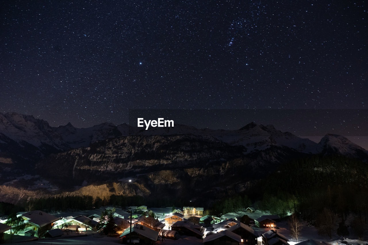 Scenic view of illuminated mountains against sky at night