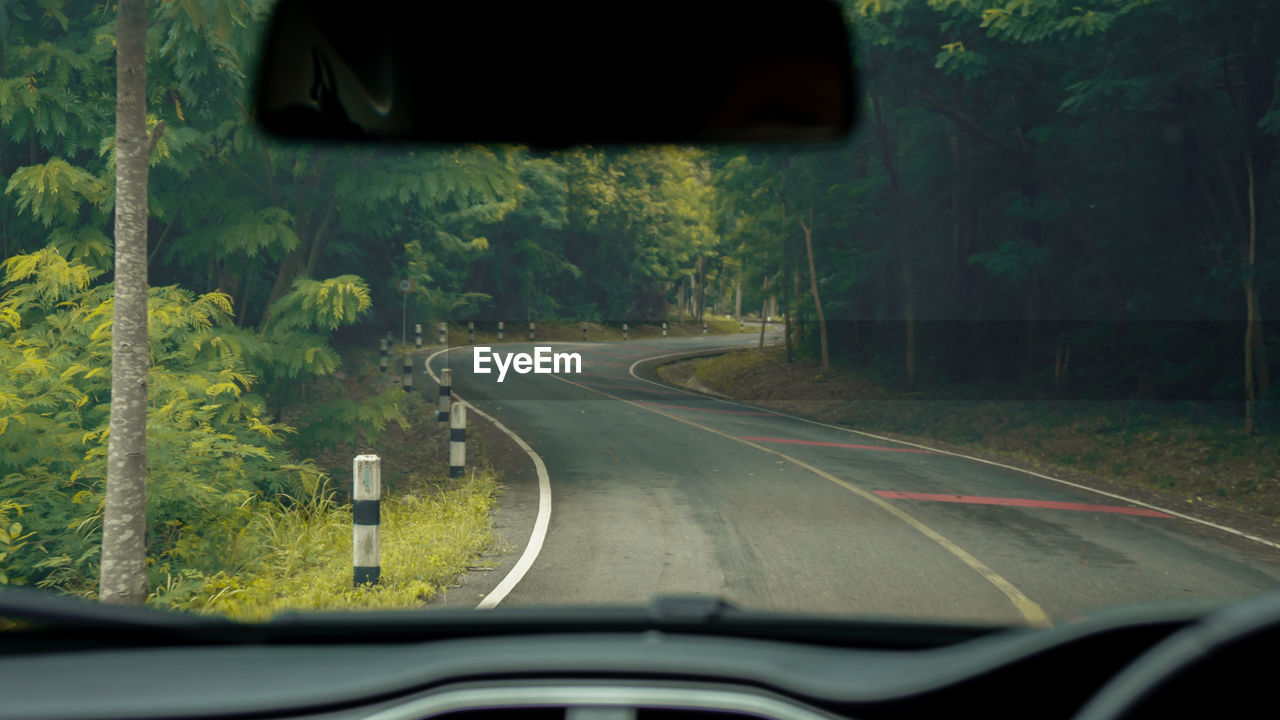 ROAD SEEN THROUGH WINDSHIELD OF CAR