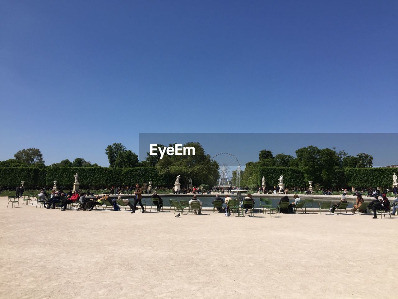 GROUP OF PEOPLE ON BEACH AGAINST CLEAR SKY