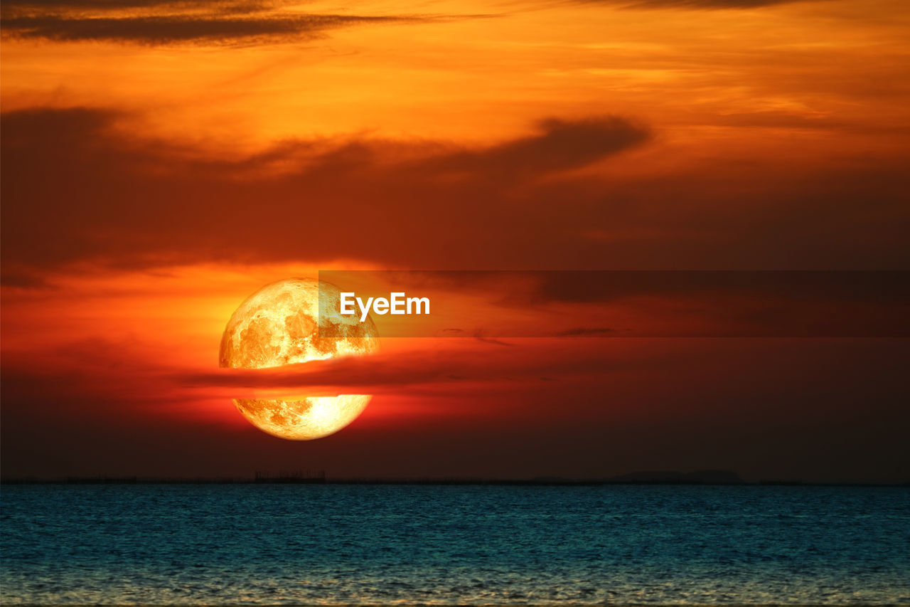 Super harvest blood moon rise back blur red cloud on the night sky over the horizon sea