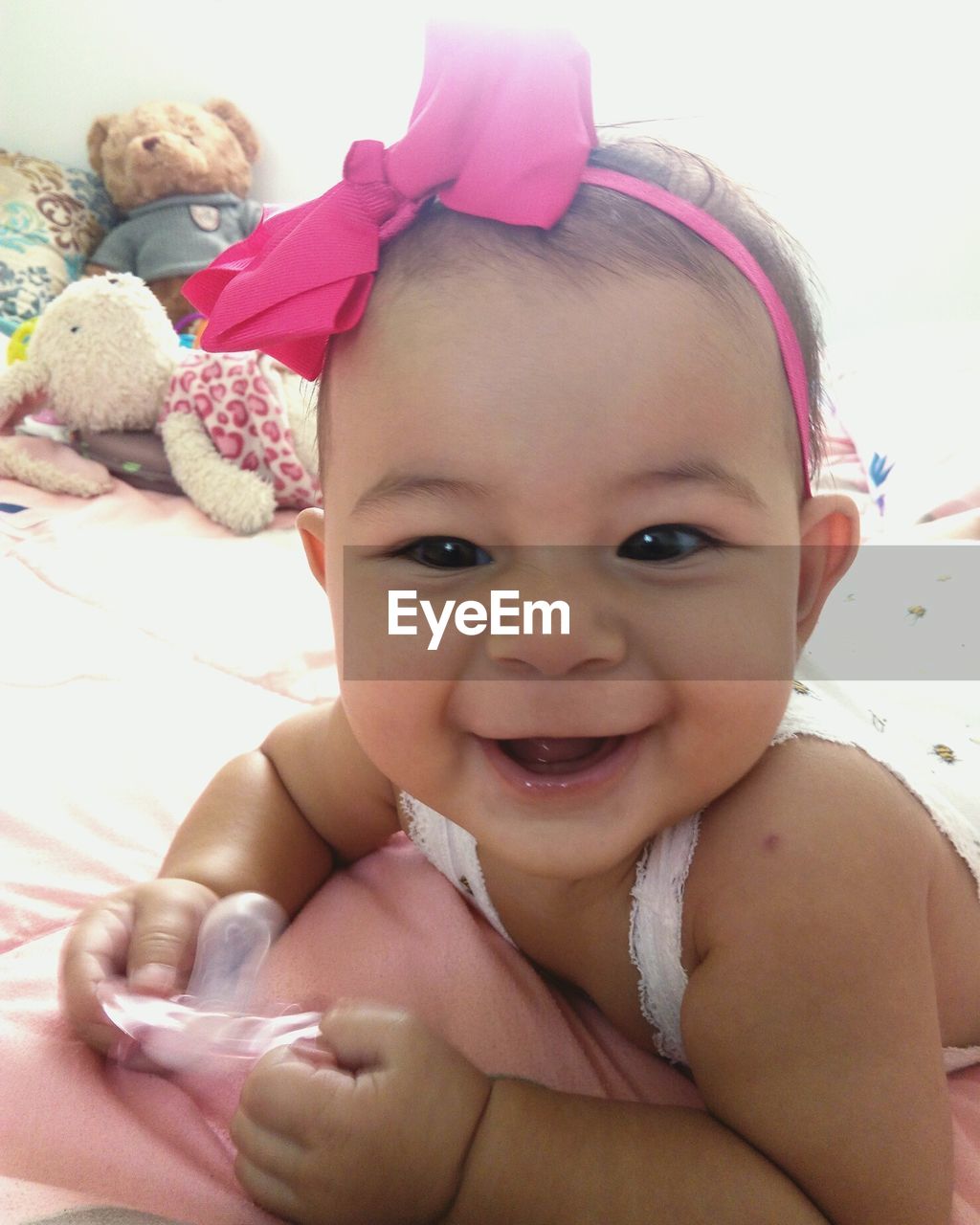 Portrait of cute baby girl lying on bed